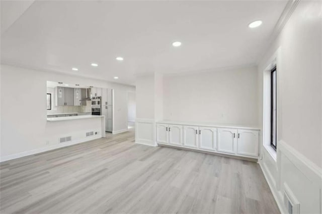 unfurnished living room with recessed lighting, light wood-style floors, visible vents, and ornamental molding