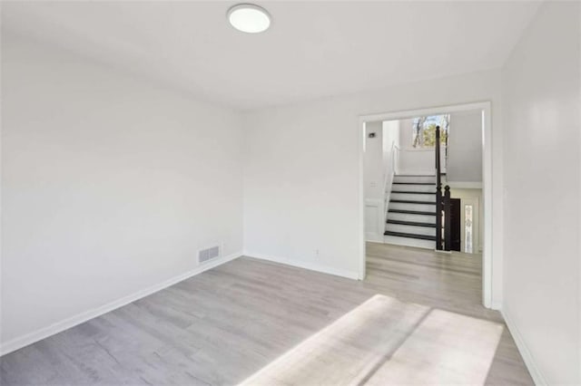 spare room with visible vents, wood finished floors, and baseboards