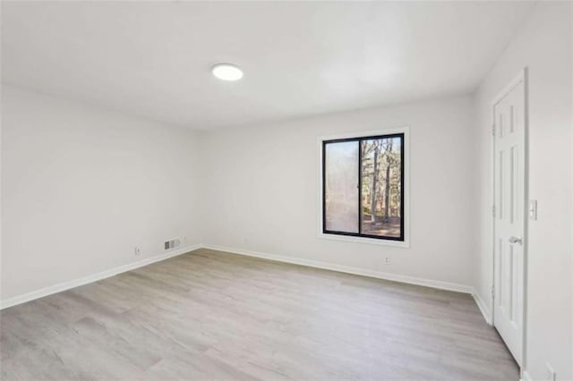 unfurnished bedroom featuring wood finished floors, visible vents, and baseboards