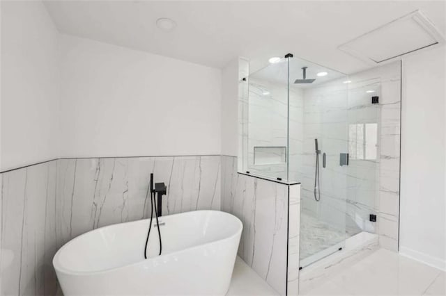 bathroom featuring a freestanding tub, recessed lighting, a wainscoted wall, and a marble finish shower