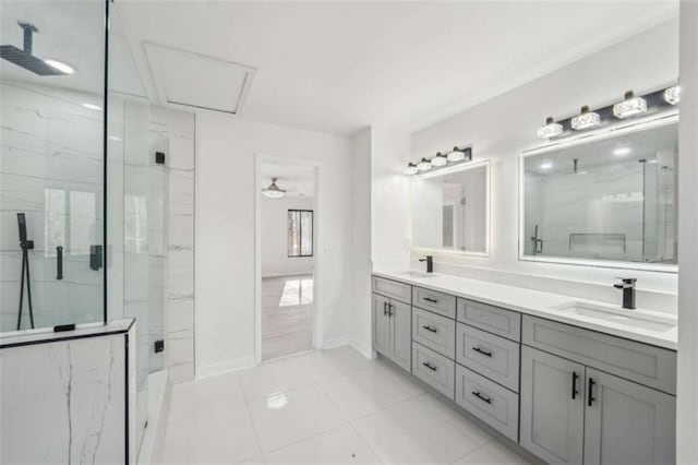 full bath featuring double vanity, baseboards, a marble finish shower, and a sink