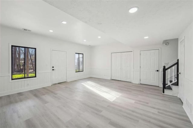 interior space featuring stairway, wood finished floors, visible vents, a wainscoted wall, and recessed lighting