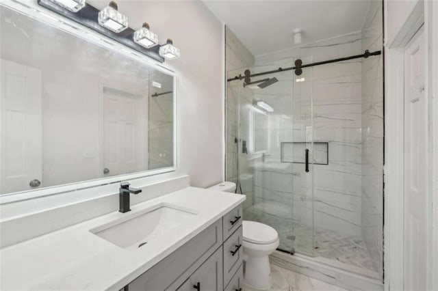 bathroom with a marble finish shower, marble finish floor, toilet, and vanity