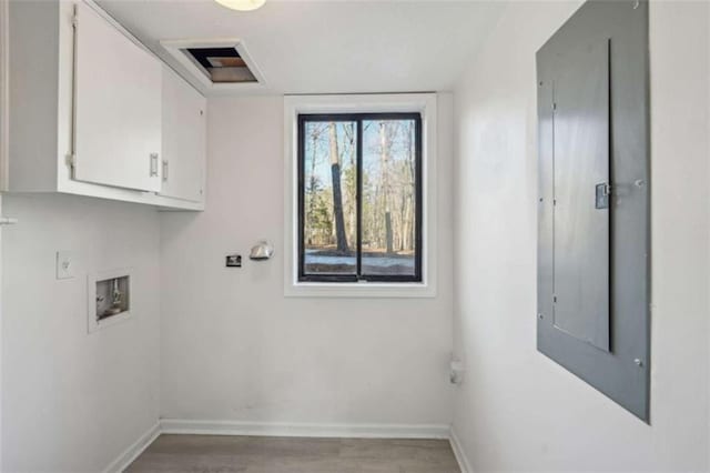 washroom with cabinet space, washer hookup, baseboards, and wood finished floors