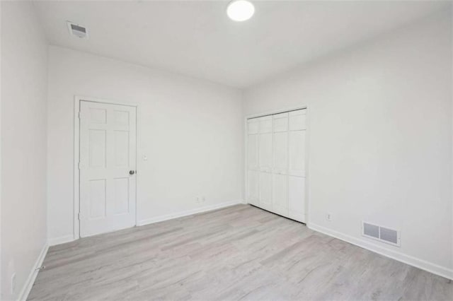 empty room featuring visible vents, baseboards, and wood finished floors