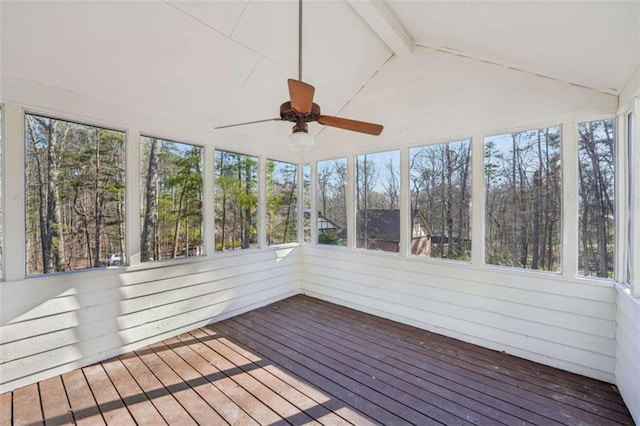 unfurnished sunroom with a wealth of natural light, lofted ceiling with beams, and ceiling fan