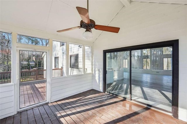 unfurnished sunroom with a wealth of natural light, vaulted ceiling with beams, and ceiling fan