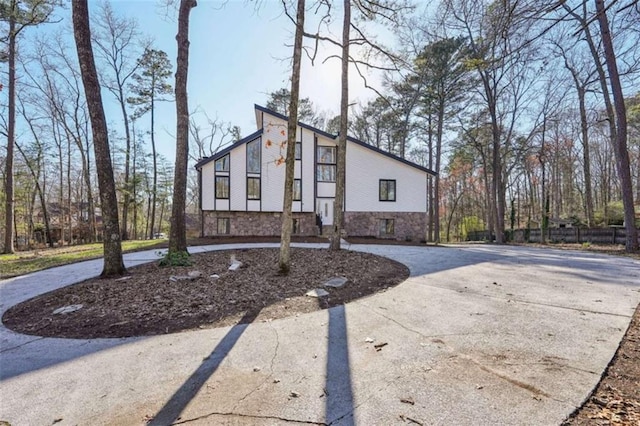 view of front of property with fence and curved driveway