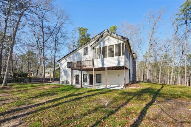 back of property with a patio, a lawn, and a sunroom