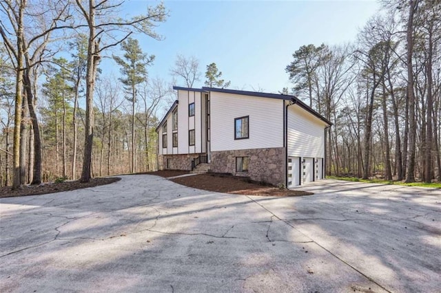 view of side of property with a garage and concrete driveway