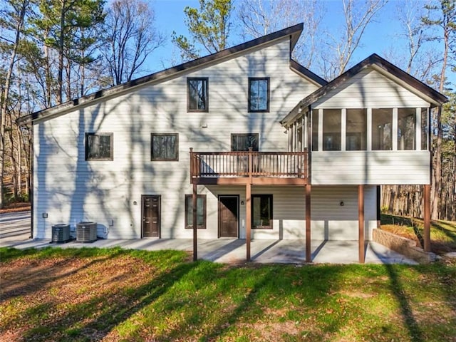 rear view of house with a patio area, a lawn, cooling unit, and a sunroom