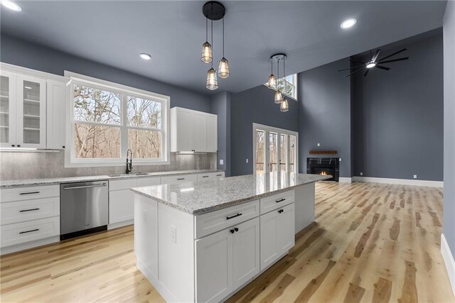 kitchen featuring a kitchen island, decorative light fixtures, sink, white cabinets, and stainless steel appliances