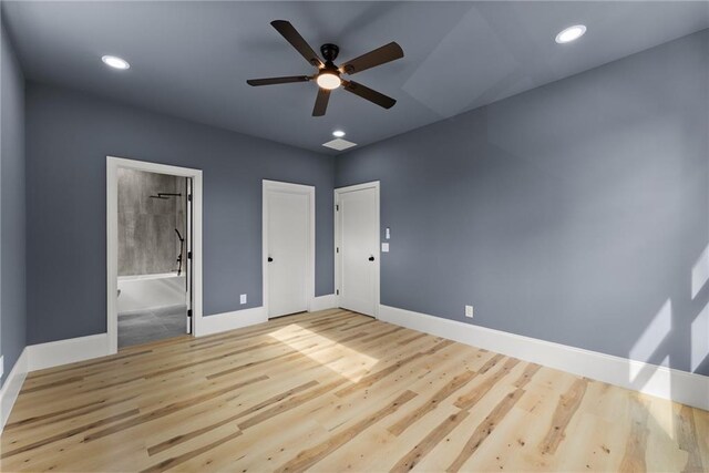 empty room with ceiling fan and light hardwood / wood-style floors