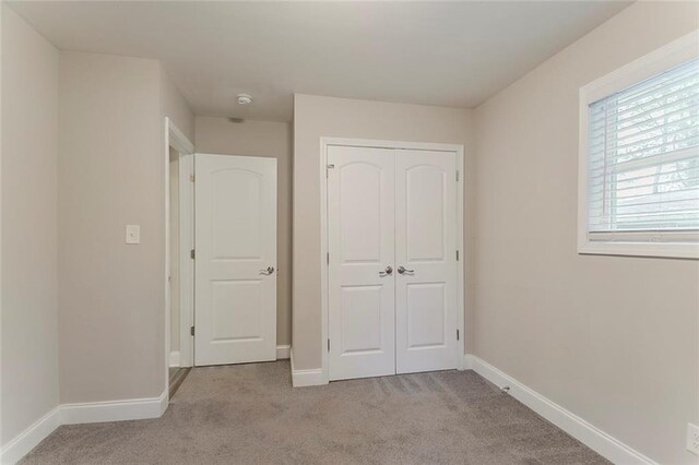 2682 Cavalier Dr, Decatur, GA 30034 - unfurnished bedroom featuring a closet, baseboards, and carpet floors