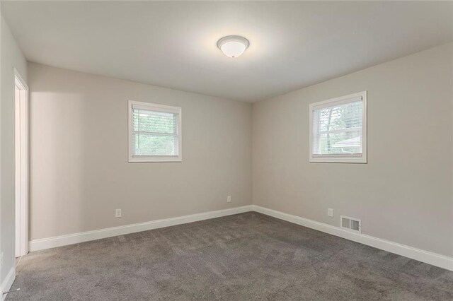 2682 Cavalier Dr, Decatur, GA 30034 - empty room with plenty of natural light, visible vents, baseboards, and dark carpet