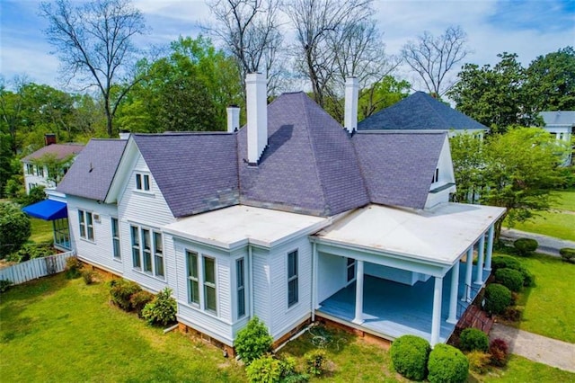 rear view of property with a lawn