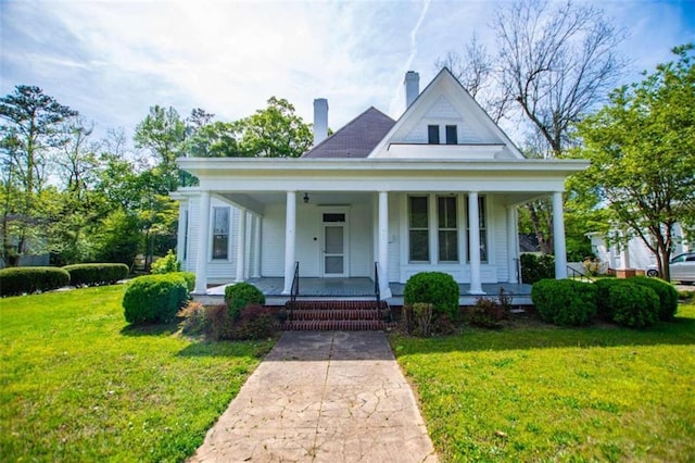 view of front of home with covered porch and a front yard