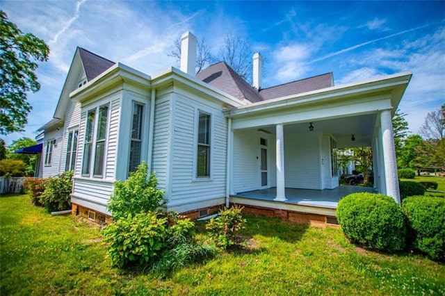 rear view of house with a lawn and covered porch