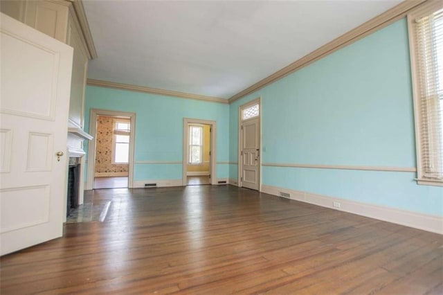 unfurnished living room featuring crown molding and dark wood-type flooring