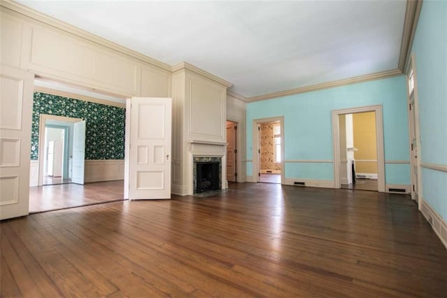 unfurnished living room with ornamental molding, dark wood-type flooring, and a high end fireplace