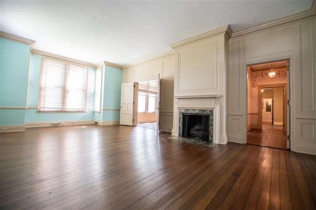 unfurnished living room featuring crown molding, dark wood-type flooring, and a fireplace