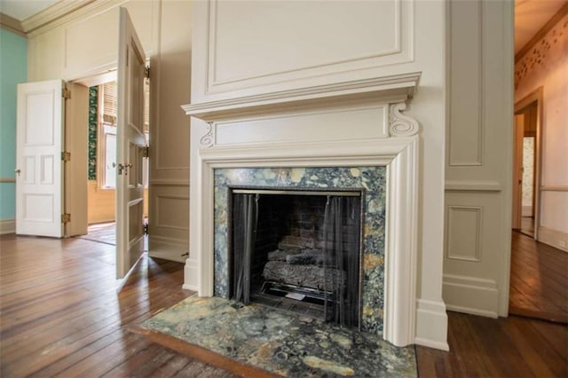 interior details featuring crown molding, hardwood / wood-style floors, and a fireplace