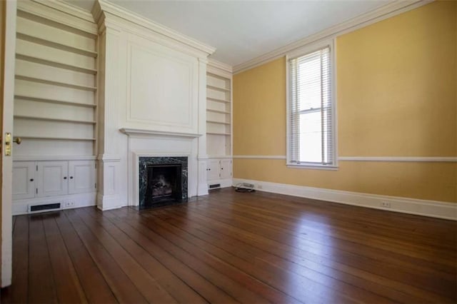 unfurnished living room with ornamental molding, dark hardwood / wood-style floors, a fireplace, and built in shelves