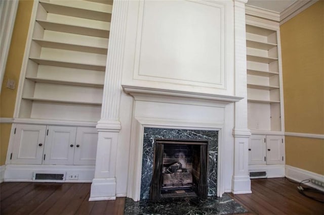 room details with hardwood / wood-style flooring, a high end fireplace, crown molding, and built in features