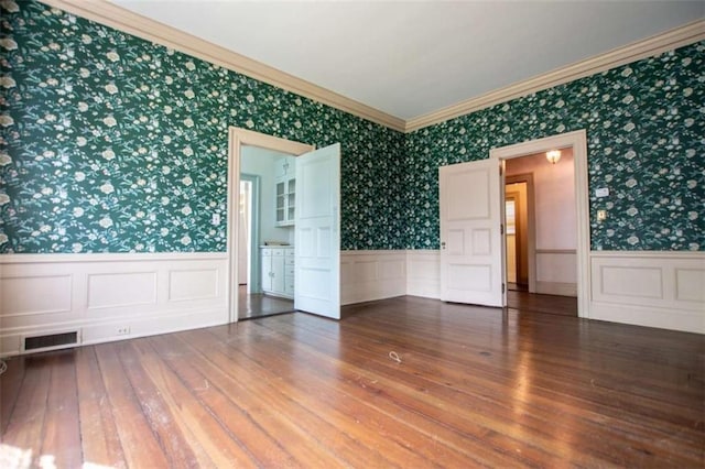 empty room featuring dark wood-type flooring and crown molding