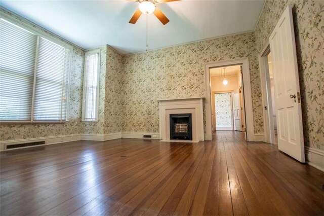 unfurnished living room with dark hardwood / wood-style flooring and ceiling fan