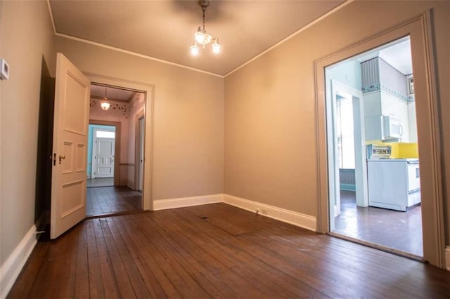 spare room featuring ornamental molding and dark hardwood / wood-style floors