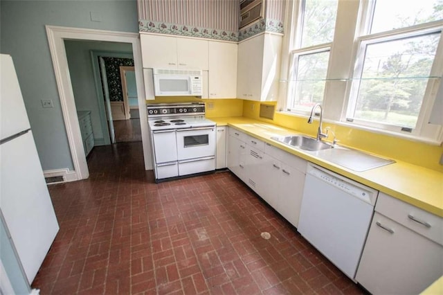 kitchen with white cabinetry, white appliances, and sink