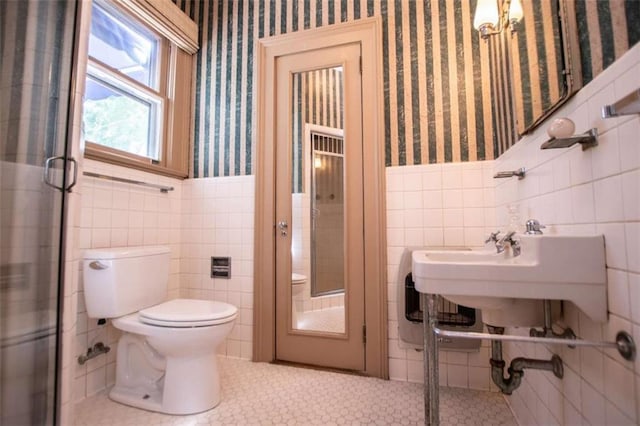 bathroom featuring tile walls, tile patterned flooring, and toilet