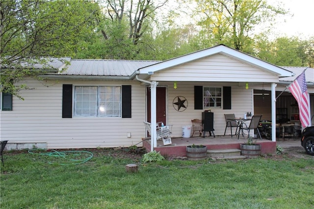 back of property with a porch and a lawn