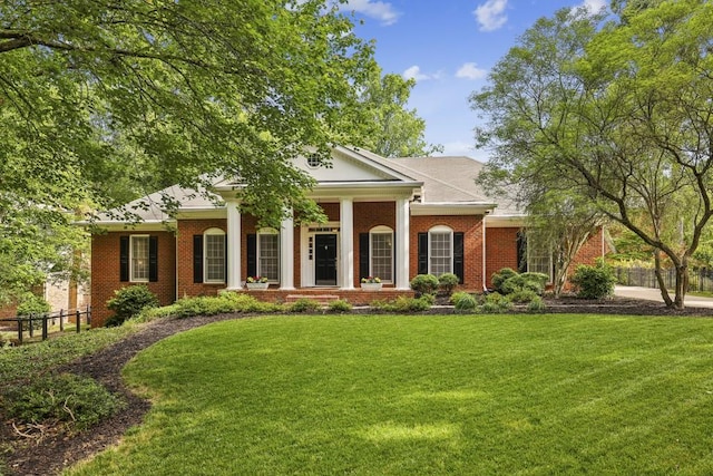 neoclassical / greek revival house featuring brick siding and a porch