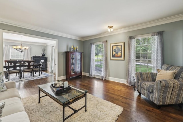 living area featuring a chandelier, ornamental molding, baseboards, and dark wood-type flooring