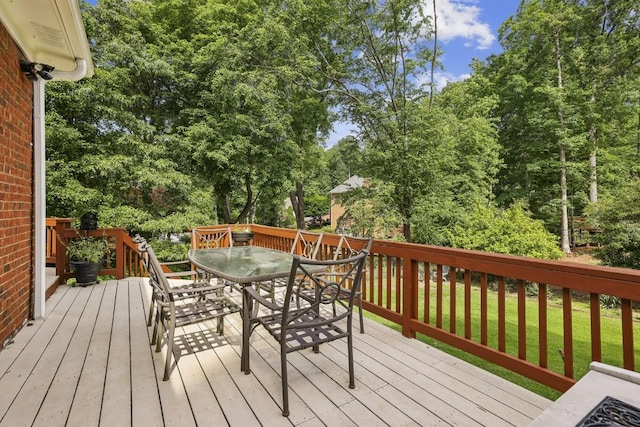 deck with outdoor dining area and a yard