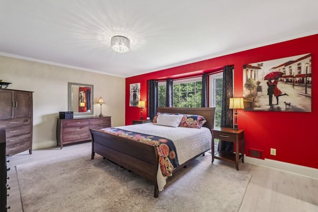 bedroom with ornamental molding, baseboards, and light wood-style floors
