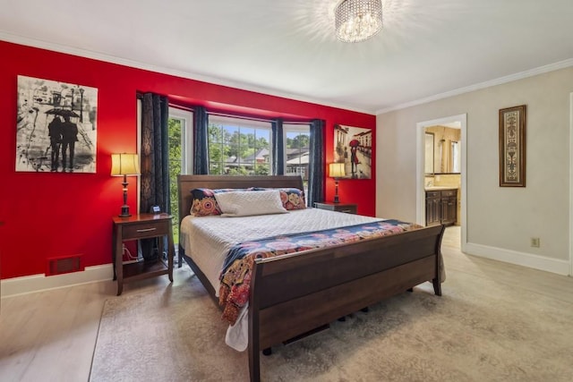 bedroom with crown molding, a chandelier, baseboards, and ensuite bath