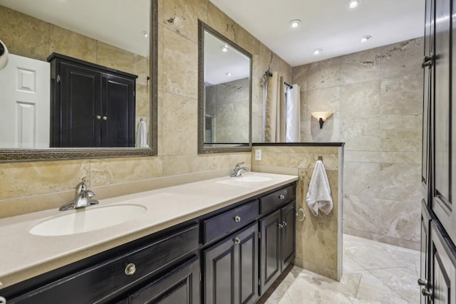 bathroom featuring tile walls, double vanity, tiled shower, and tasteful backsplash