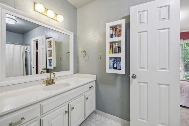 bathroom featuring vanity, baseboards, and tile patterned floors