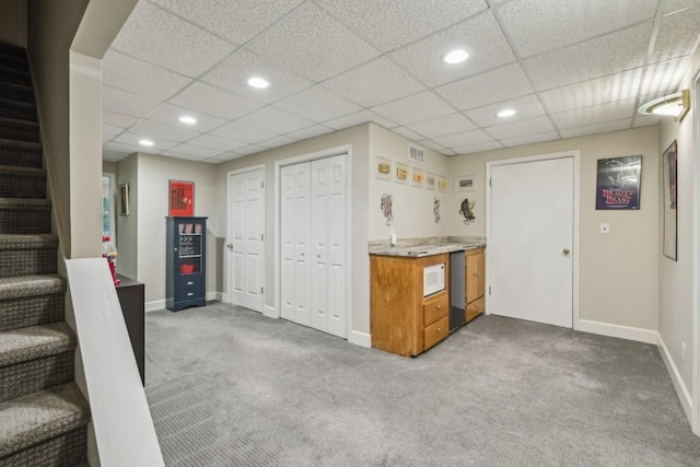 kitchen featuring brown cabinets, carpet, light countertops, baseboards, and recessed lighting
