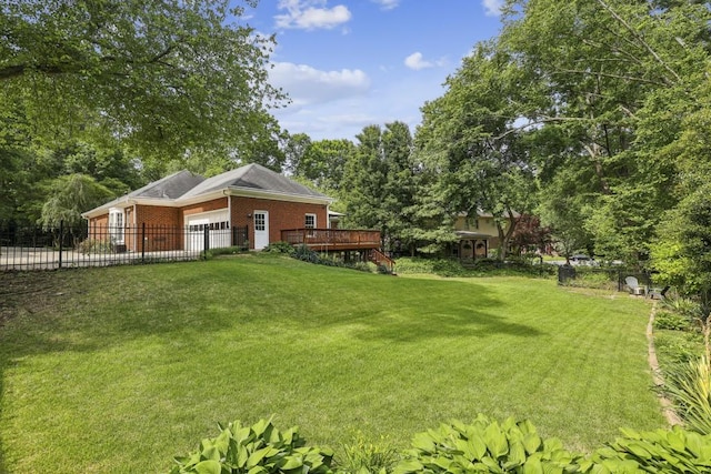 view of yard featuring a garage, a wooden deck, and view of scattered trees