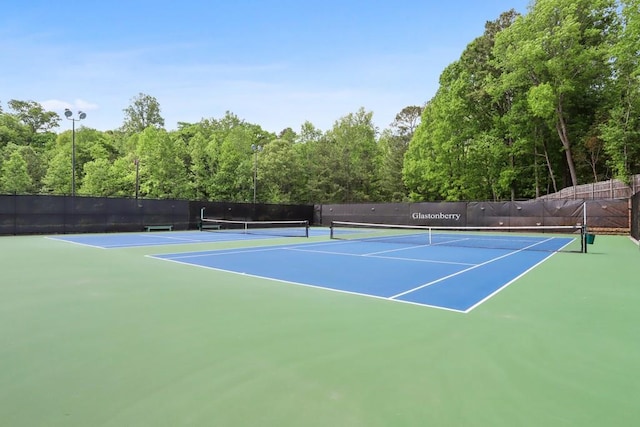 view of tennis court with fence and community basketball court