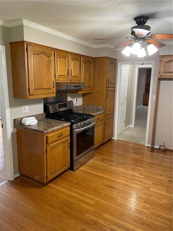 240 W Huntington Rd, Bogart, GA 30622 - kitchen with gas stove, brown cabinets, light wood-style floors, under cabinet range hood, and a textured ceiling