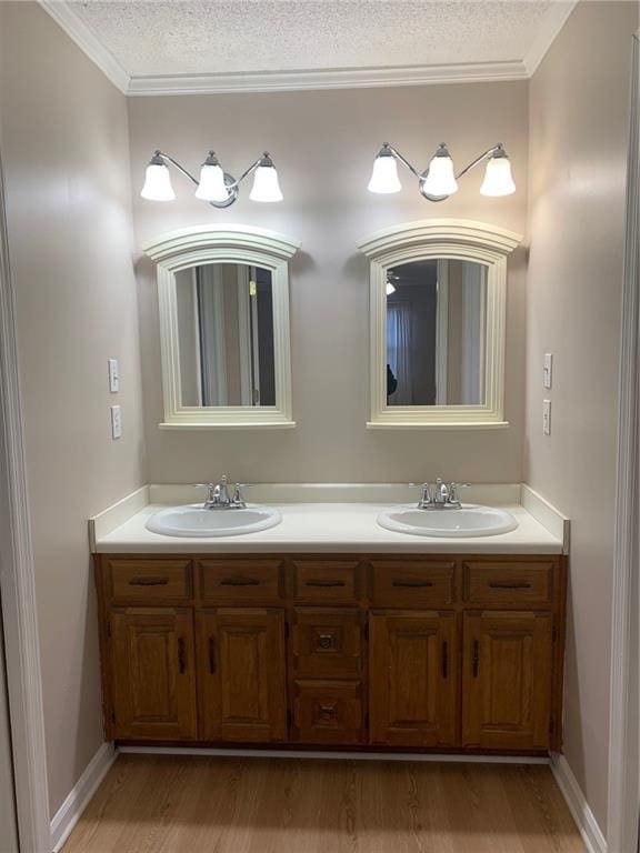 240 W Huntington Rd, Bogart, GA 30622 - bathroom with double vanity, a textured ceiling, wood finished floors, crown molding, and baseboards