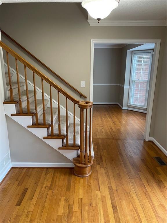240 W Huntington Rd, Bogart, GA 30622 - stairs featuring ornamental molding, wood finished floors, and baseboards