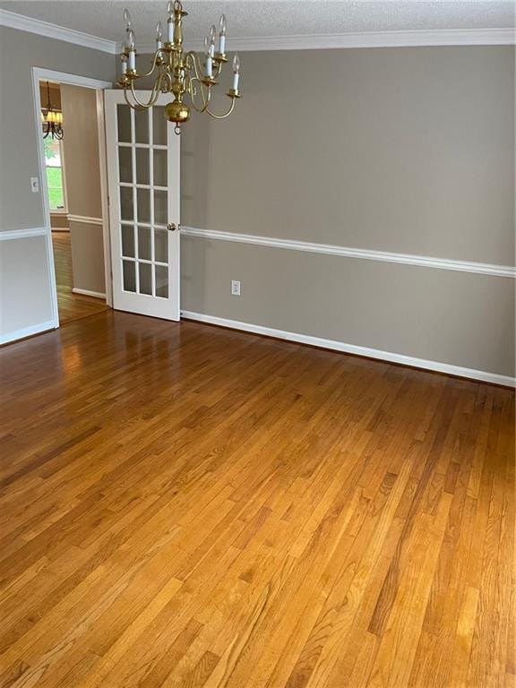 240 W Huntington Rd, Bogart, GA 30622 - empty room featuring a chandelier, a textured ceiling, wood finished floors, baseboards, and crown molding