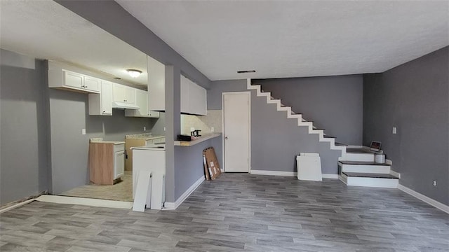 kitchen with light hardwood / wood-style flooring and white cabinets