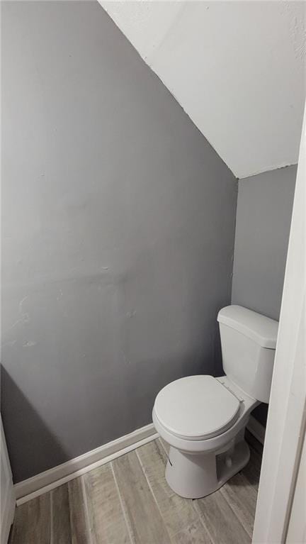 bathroom featuring lofted ceiling, wood-type flooring, and toilet